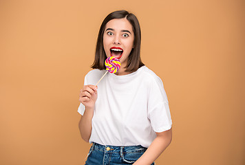 Image showing The young woman with colorful lollipop