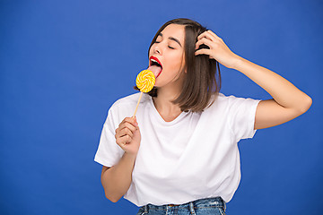 Image showing The young woman with colorful lollipop