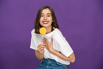 Image showing The young woman with colorful lollipop