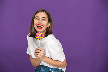 Image showing The young woman with colorful lollipop