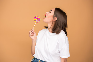 Image showing The young woman with colorful lollipop