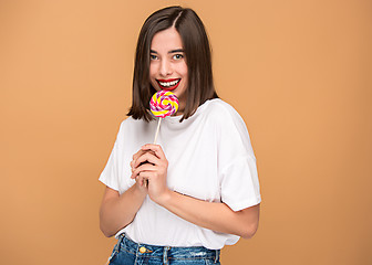 Image showing The young woman with colorful lollipop