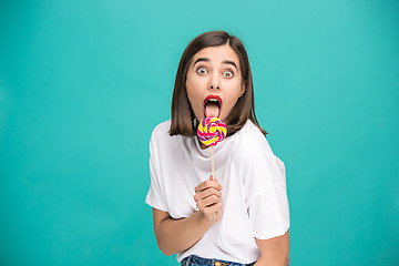 Image showing The young woman with colorful lollipop