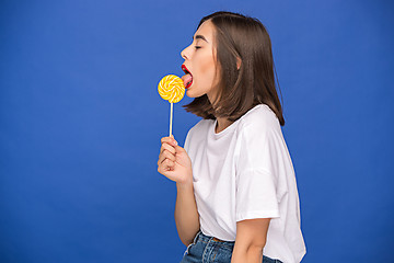 Image showing The young woman with colorful lollipop