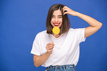 Image showing The young woman with colorful lollipop