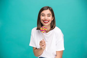 Image showing The young woman with colorful lollipop