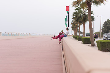 Image showing mother and cute little girl on the promenade by the sea