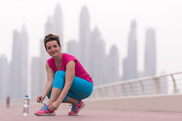 Image showing woman tying shoelaces on sneakers