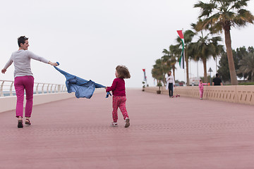 Image showing mother and cute little girl on the promenade by the sea