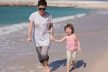 Image showing mother and daughter running on the beach