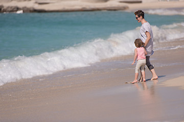 Image showing mother and daughter running on the beach