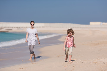 Image showing mother and daughter running on the beach