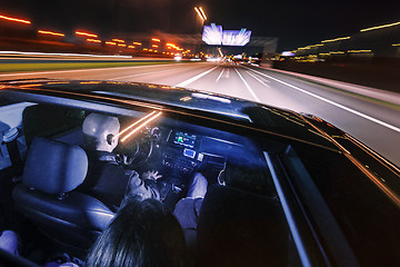 Image showing couple of friends in a luxury car driving at night