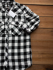 Image showing close up of checkered shirt on wooden background