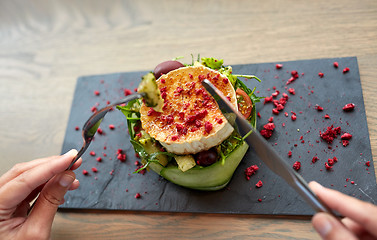 Image showing woman eating goat cheese salad at restaurant