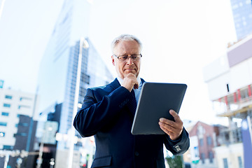 Image showing senior businessman with tablet pc on city street
