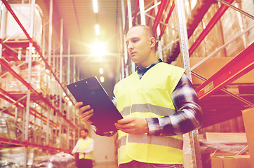 Image showing man with clipboard in safety vest at warehouse