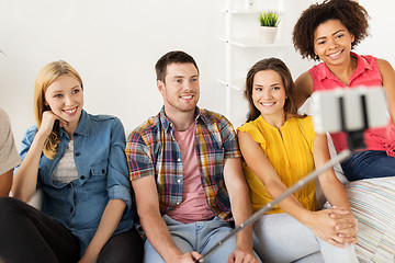 Image showing happy friends taking selfie by smartphone at home