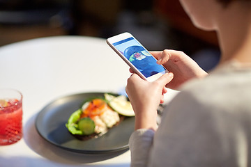 Image showing woman with smartphone photographing food at cafe