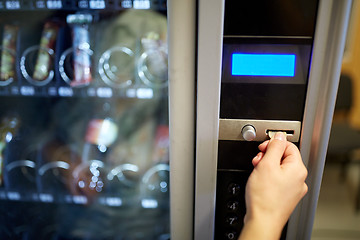 Image showing hand inserting euro coin to vending machine slot