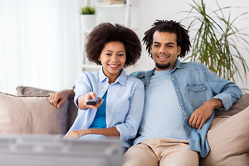 Image showing smiling couple with remote watching tv at home