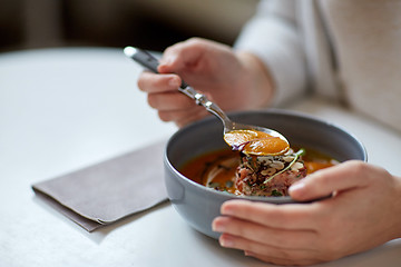 Image showing woman eating pumpkin cream soup at restaurant