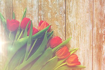 Image showing close up of red tulips on wooden background