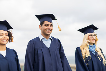 Image showing happy students or bachelors in mortar boards