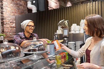 Image showing happy woman buying chai latte drink at vegan cafe