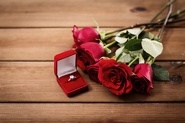 Image showing close up of diamond engagement ring and red roses