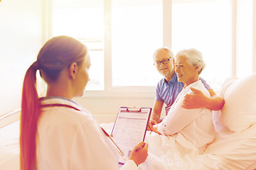 Image showing senior woman and doctor with clipboard at hospital