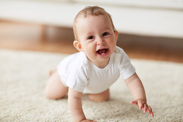 Image showing little baby in diaper crawling on floor at home