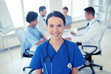 Image showing happy doctor over group of medics at hospital