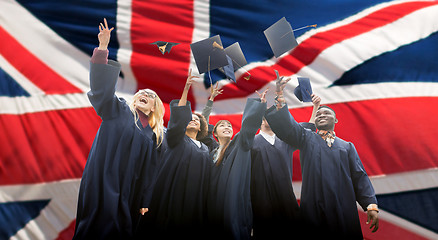 Image showing happy students throwing mortarboards up