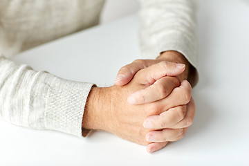 Image showing close up of senior man hands on table