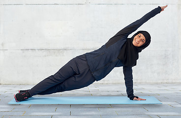 Image showing muslim woman doing sport on mat