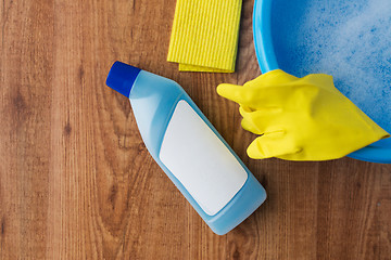 Image showing basin with cleaning stuff on wooden background