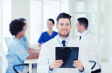 Image showing happy doctor with tablet pc over team at clinic