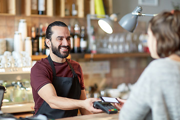 Image showing barman and woman with card reader and smartphone