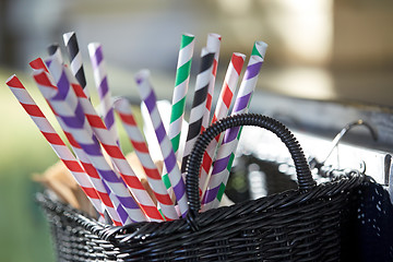 Image showing disposable straws in whickered basket outdoors