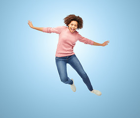 Image showing happy african american woman jumping over white