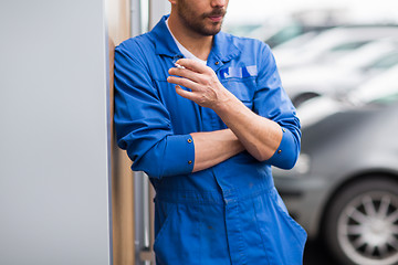 Image showing close up of auto mechanic smoking cigarette