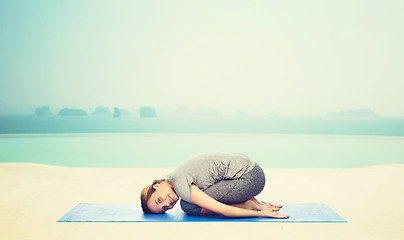 Image showing happy woman making yoga in child pose on mat