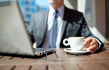 Image showing senior businessman with laptop and coffee outdoors