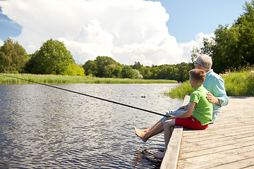 Image showing grandfather and grandson fishing on river berth