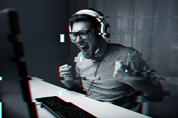 Image showing man in headset playing computer video game at home