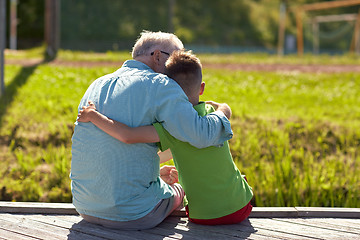 Image showing grandfather and grandson hugging on berth