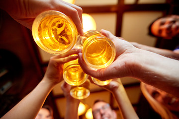 Image showing friends clinking beer glasses at pub or bar