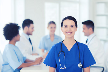 Image showing happy doctor over group of medics at hospital