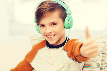 Image showing happy boy in headphones showing thumbs up at home